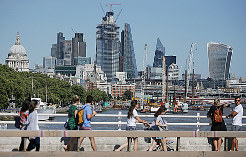 LONDON: Skyscrapers and office buildings are pictured in the City of London as pedestrians use Waterloo Bridge to cross over the River Thames. —AFP