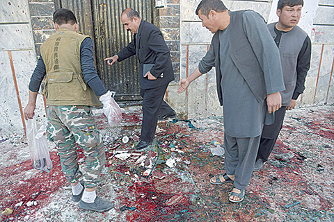 EDITORS NOTE: Graphic content / (FILES) In this file photo taken on April 22, 2018, Afghan residents inspect the site of a suicide bombing outside a voter registration centre in Kabul. - After a year of record bloodshed Afghans are bracing for an even deadlier 2019, with the threat of a US drawdown and a looming presidential vote likely to fuel violence. (Photo by SHAH MARAI / AFP) / TO GO WITH AFGHANISTAN-UNREST,FOCUS BY ALLISON JACKSON