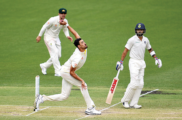 PERTH: Australia's paceman Mitchell Starc (C) bowls as India's batsman Virat Kohli (R) looks on during day two of the second Test cricket match between Australia and India in Perth yesterday. - AFP