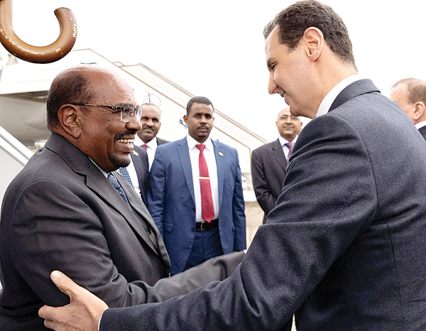 DAMASCUS: President Bashar Al-Assad receives his Sudanese counterpart Omar Al-Bashir upon his arrival at the airport in the Syrian capital on Sunday. - AFP 