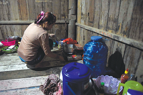 PHNOM PENH: Nary, a Cambodian victim of forced marriage to a Chinese man, cooks at home in Phnom Penh. — AFP photos