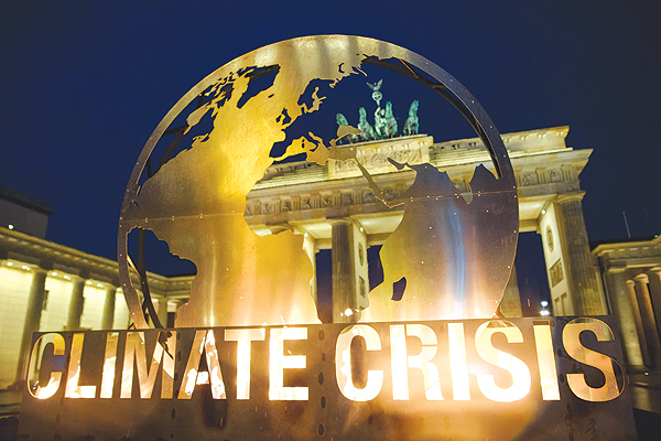 BERLIN: Berlin’s landmark the Brandenburg Gate is seen through a giant globe installation erected by Greenpeace environmentalists yesterday. — AFP