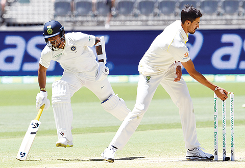 PERTH: Australia's paceman Mitchell Starc makes an unsuccessful attempt to run out India's batsman Umesh Yadav (L) during day five of the second cricket match between Australia and India in Perth yesterday. - AFP