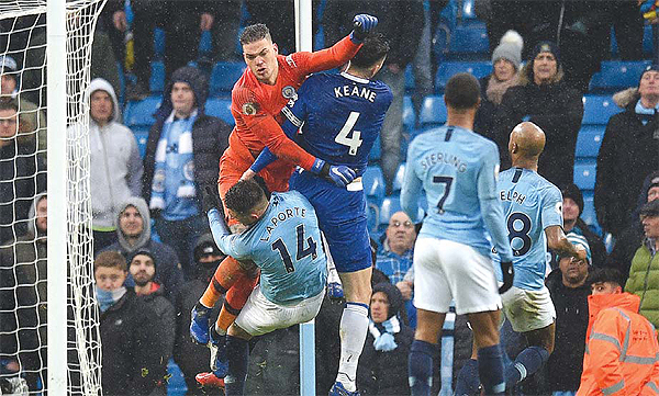 LONDON: Manchester City’s French defender Aymeric Laporte (center) and Everton’s English defender Michael Keane (center R) clash with Manchester City’s Brazilian goalkeeper Ederson (L) during the English Premier League football match between Manchester City and Everton at the Etihad Stadium yesterday. — AFP