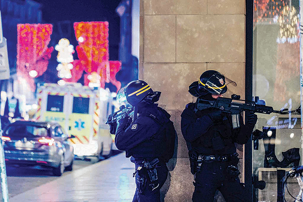 STRASBOURG, France: French police officers stand guard near the scene of a shooting on Tuesday. - AFP 