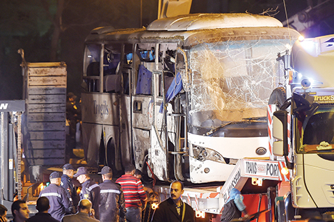 TOPSHOT - This picture taken on December 28, 2018 shows a tourist bus which was attacked being towed away from the scene, in Giza province south of the Egyptian capital Cairo. - Three Vietnamese holidaymakers and an Egyptian tour guide were killed and 10 others wounded on December 28 when a roadside bomb exploded near their bus as it travelled close to the Giza pyramids in Cairo, Egypt's interior ministry said in a statement. (Photo by MOHAMED EL-SHAHED / AFP)