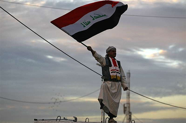 An Iraqi man waves his national flag in Baghdad's Tahrir Square on December 10, 2017, during a gathering celebrating the end of the three-year war against the Islamic State (IS) group  - AFP