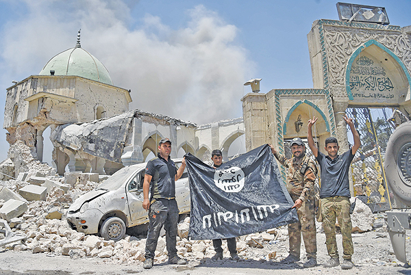 Photo shows members of the Iraqi Counter-Terrorism Service (CTS) with a flag of the Islamic State held upside-down, outside the destroyed Al-Nuri Mosque in the Old City of Mosul, after the area was retaken from IS. Even as the last pockets of resistance in eastern Syria hold their ground, the Islamic State group is shapeshifting into a new, but no less dangerous, underground form, experts warn. — AFP
