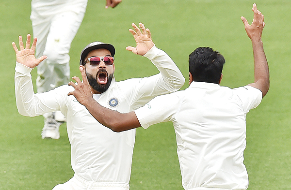 ADELAIDE: India's captain Virat Kohli (L) celebrates with spin bowler Ravichandran Ashwin (R) after beating Australia on day five of the first Test cricket match at the Adelaide Oval yesterday. - AFPn