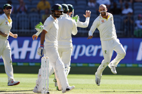 PERTH: Australia’s bowler Nathan Lyon (R) celebrates after dismissing India’s Virat Kohli (C) during day four of the second Test cricket match between Australia and India in Perth yesterday. — AFP