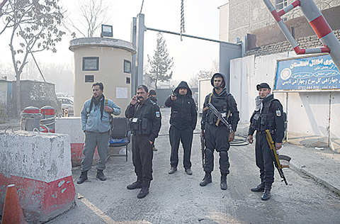 Aghan policemen stand guards at the entrance gate of the Ministry of Public Works a day after a deadly militant attack in Kabul on December 25, 2018. - An hours-long gun and suicide attack on a Kabul government compound killed at least 43 people, the health ministry said December 25, making it one of the deadliest assaults on the Afghan capital this year. (Photo by WAKIL KOHSAR / AFP)