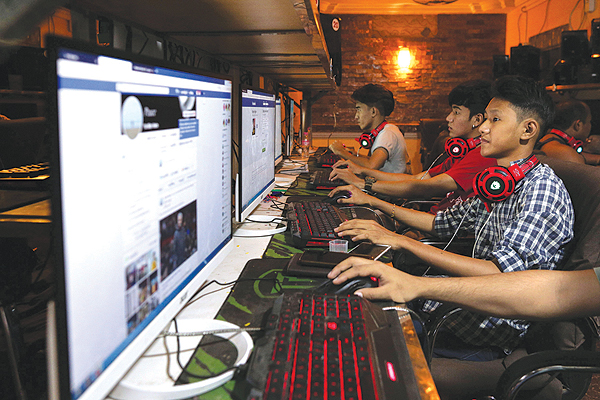 YANGON: Myanmar youths browse their Facebook page at an internet shop in Yangon. Facebook has removed hundreds of additional pages and accounts in Myanmar with hidden links to the military, the platform said yesterday, as the company scrambles to respond to criticism over failures to control hate speech and misinformation. - AFP