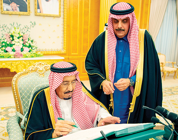 RIYADH: Saudi King Salman bin Abdulaziz signs on the 2019 budget following a meeting yesterday. — AFP