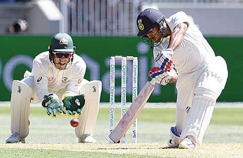India's batsman Mayank Agarwal (R) plays a shot as Australia's wicketkeeper Tim Paine looks on during day one of the third cricket Test match between Australia and India in Melbourne on December 26, 2018. (Photo by WILLIAM WEST / AFP) / -- IMAGE RESTRICTED TO EDITORIAL USE - STRICTLY NO COMMERCIAL USE --