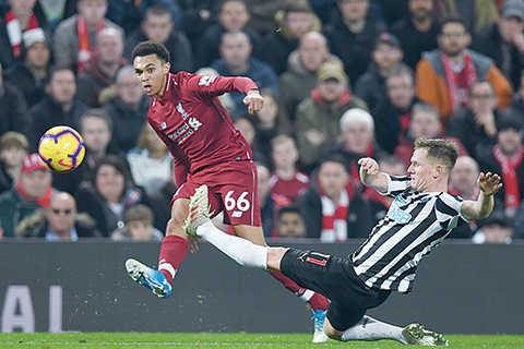 Liverpool's English defender Trent Alexander-Arnold (L) crosses the ball as Newcastle United's Scottish midfielder Matt Ritchie (R) attempts a block during the English Premier League football match between Liverpool and Newcastle United at Anfield in Liverpool, north west England on December 26, 2018. - Liverpool won the game 4-0. (Photo by Paul ELLIS / AFP) / RESTRICTED TO EDITORIAL USE. No use with unauthorized audio, video, data, fixture lists, club/league logos or 'live' services. Online in-match use limited to 120 images. An additional 40 images may be used in extra time. No video emulation. Social media in-match use limited to 120 images. An additional 40 images may be used in extra time. No use in betting publications, games or single club/league/player publications. /