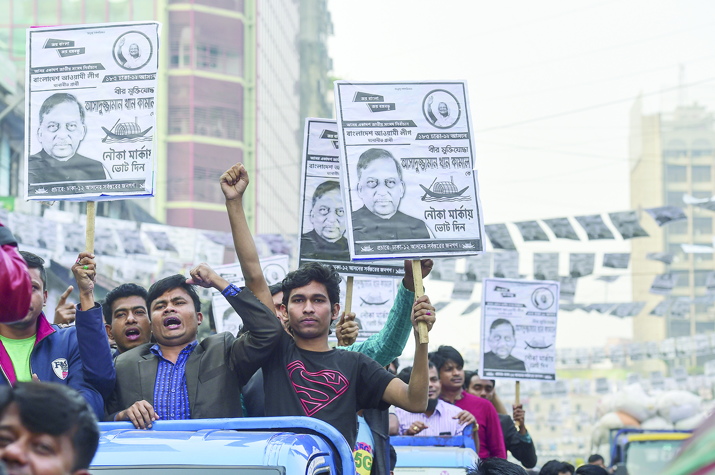 Supporters of Bangladesh Awami League march in the street as they take part in a general election campaign procession in Dhaka on December 26, 2018. - New clashes marred the deadly Bangladesh election campaign on December 26 as opposition leaders stepped up complaints over the organisation of what they consider a one-sided vote. (Photo by MUNIR UZ ZAMAN / AFP)