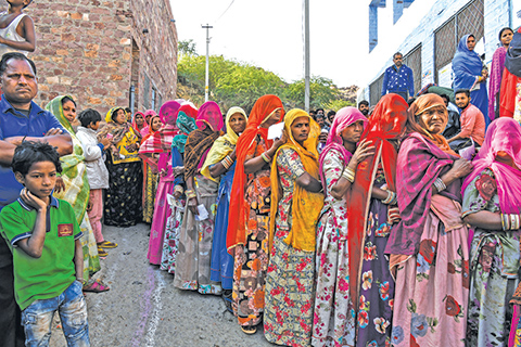 Indian women stand in queue to cast their vote at a local polling station during Rajasthan's Legislative Assembly election, in Jodhpur on December 7, 2018. - The Indian state of Rajasthan votes on December 7 in an election that is a key test for Prime Minister Narendra Modi. (Photo by CHANDAN KHANNA / AFP)