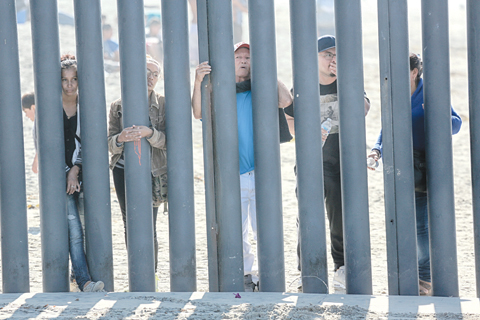 In this file photo taken on November 18, 2018, would-be migrants to the United states from Honduras peer through the fence demarcating the US-Mexico border in San Ysidro, California. - AFP 