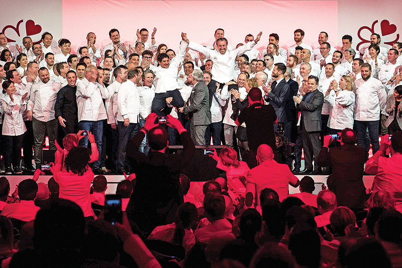 Italian-Argentinian chef Mauro Colagreco (center left) and French chef Laurent Petit (Center right) react on stage with French chef Alain Ducasse (center) after they were awarded three Michelin stars during the Michelin guide award ceremony in Paris on January 21, 2019. — AFP