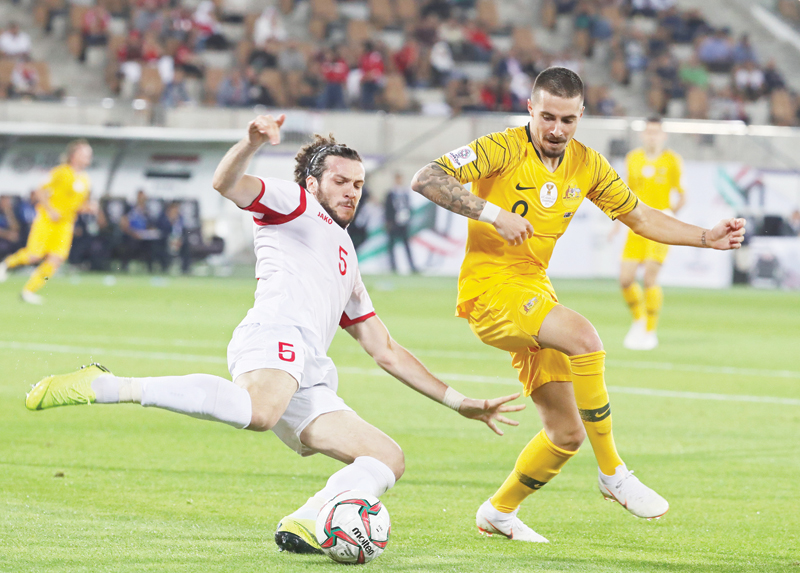 AL-AIN: Syria’s defender Omar Midani (L) fights for the ball against Australia’s forward Jamie Maclaren during the 2019 AFC Asian Cup group B football match between Australia and Syria at the Khalifa bin Zayed stadium in al-Ain yesterday. — AFP