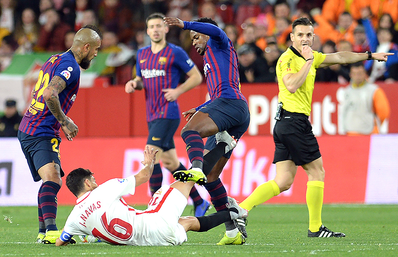 SEVILLE: Sevilla's Spanish midfielder Jesus Navas (bottom) fights for the ball with Barcelona's Portuguese defender Nelson Semedo (2R) during the Spanish Copa del Rey (King's Cup) quarter-final first leg football match between Sevilla FC and FC Barcelona at the Ramon Sanchez Pizjuan stadium in Seville. – AFP
