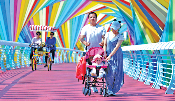 QINGDAO: This file picture shows people walking past a bridge adorned with rainbow-colored arches in Qingdao in China’s eastern Shandong. — AFP