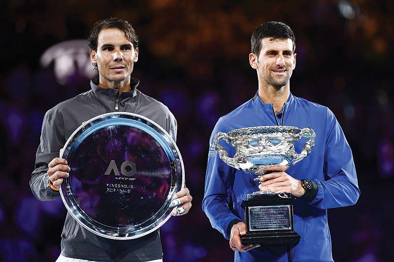 MELBOURNE: Serbia's Novak Djokovic (R) celebrates with the championship trophy during the presentation ceremony after his victory against Spain's Rafael Nadal (L) in the men's singles final on day 14 of the Australian Open tennis tournament in Melbourne yesterday. - AFP
