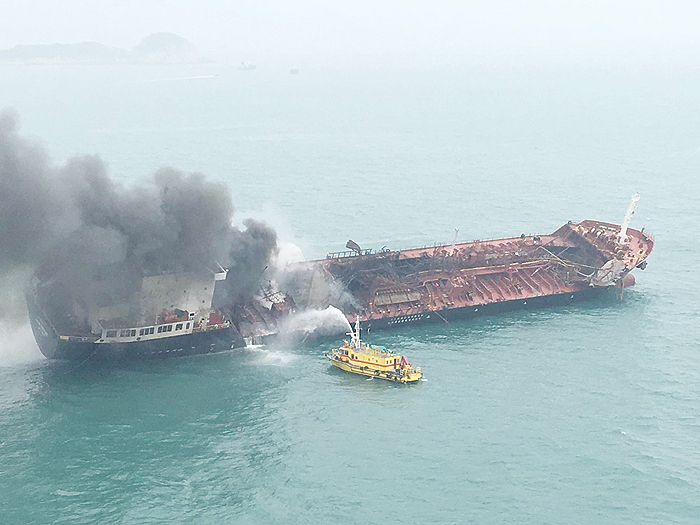 A handout photo taken yesterday and made available by the Hong Kong Government Flying Service shows a fire rescue ship spraying water towards the burning oil tanker ‘Aulac Fortune’ off the coast in southern Hong Kong. —AFP
