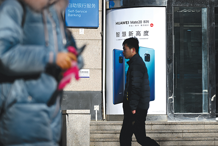 BEIJNG: Pedestrians walk past a Huawei store in Beijing. — AFP