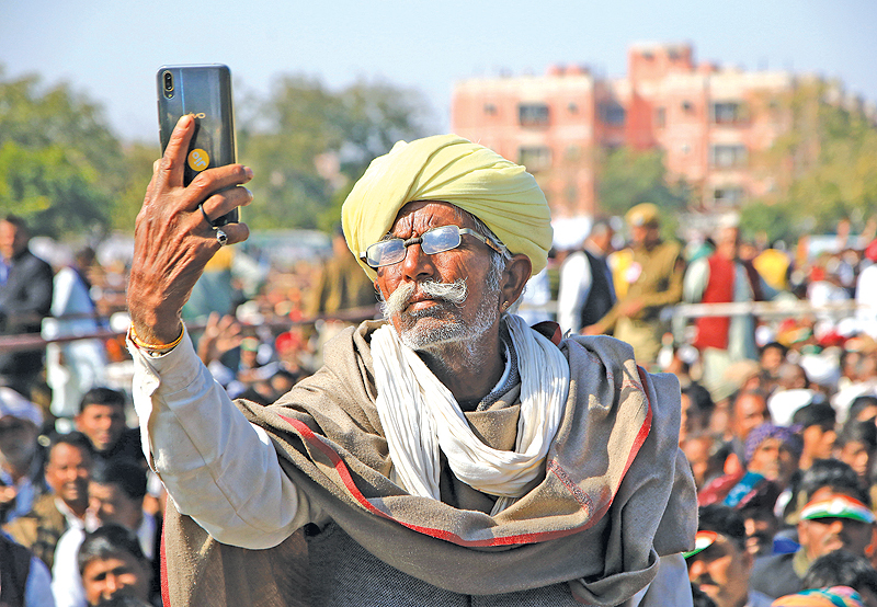 JAIPUR: An Indian farmer takes a photo on a smartphone during a rally for the farming community held by Congress Party leader Rahul Gandhi. — AFP