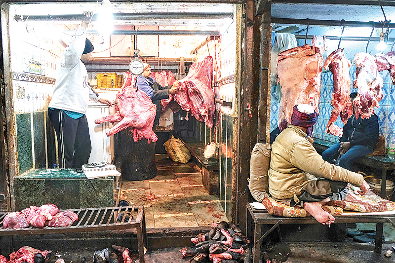 NEW DELHI: Indian butchers organize meat as they wait for costumers at their shops at a meat market in the old quarters of New Delhi yesterday. —AFP