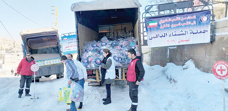 BEIRUT: Kuwait Red Crescent Society members help distribute aid material to Syrian refugees in Lebanon. —KUNA
