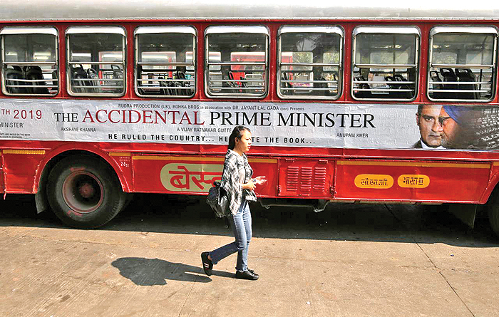 A woman walks past a bus featuring an advertising of the upcoming Bollywood film ‘The Accidental Prime Minister’ in Mumbai, India. — Reuters