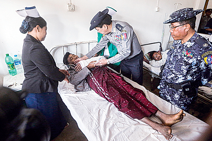 BUTHIDAUNG: Myanmar’s police chief Lieutenant General Aung Win Oo visits an injured border guard police in a hospital. —AFP