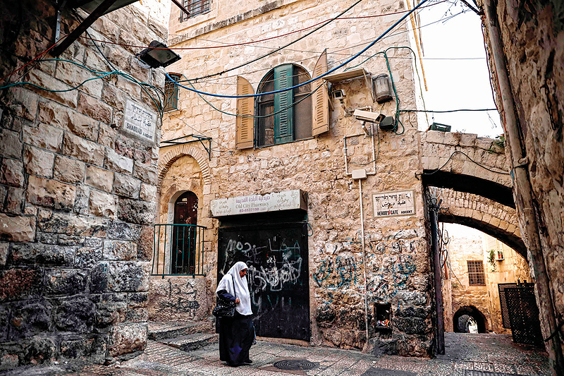 JERUSALEM: A Palestinian woman walks past a house in the Muslim Quarter of the Old City which was bought by Israeli settlers on Jan 4, 2019. - AFP 