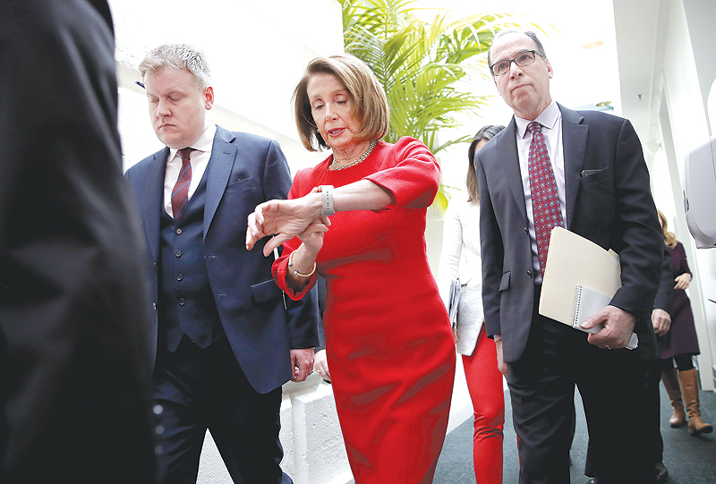 WASHINGTON DC: US Speaker of the House Nancy Pelosi (C) checks her watch while leaving a meeting of the House Democratic caucus at the US Capitol. — AFP