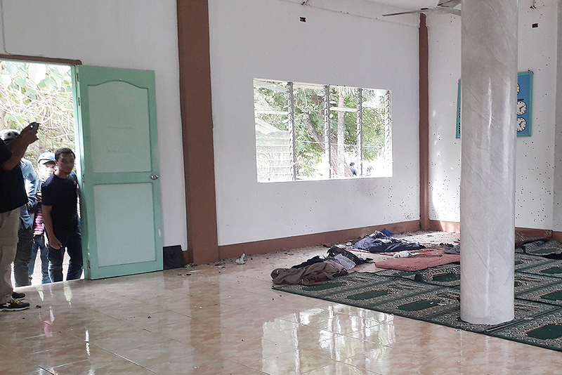 ZAMBOANGA, Philippines: People look inside a mosque on the southern island of Mindanao yesterday after a grenade attack.  - AFP 