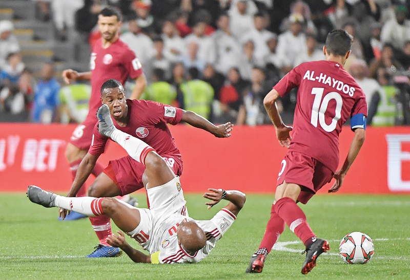 ABU DHABI: United Arab Emirates’ forward Ismaeil Al Junaibi (C) falls after a challenge from Qatar’s defender Tameem Mohammed (L) during the 2019 AFC Asian Cup semi-final football match between Qatar and UAE at the Mohammed Bin Zayed Stadium in Abu Dhabi yesterday. —AFP