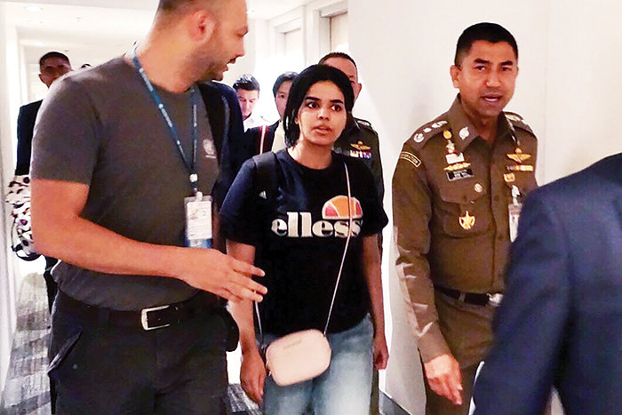 BANGKOK: This handout picture shows 18-year-old Saudi woman Rahaf Mohammed Al-Qunun being escorted by a Thai immigration officer and a United Nations High Commissioner for Refugees (UNHCR) official at Suvarnabhumi international airport yesterday. — AFP