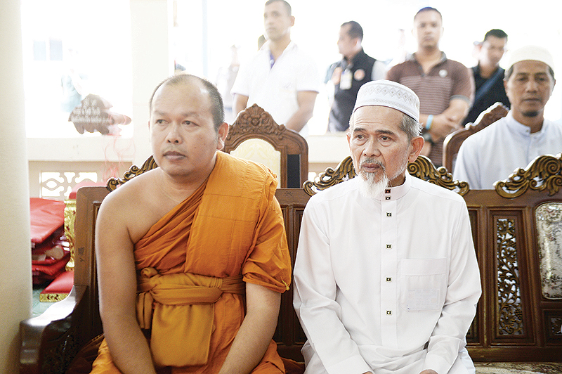 NARATHIWAT: A Buddhist monk and a Muslim village leader sit together to express sympathy and support during a gathering in Rattanaupap temple in Narathiwat province yesterday following an attack by black-clad gunmen that killed two Buddhist monks. — AFP
