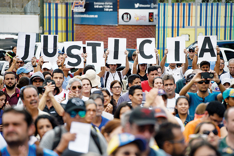 CARACAS: Venezuelan opposition supporters holding up letters reading “Justice” gather to listen to the head of Venezuela’s National Assembly and the country’s self-proclaimed “acting president” Juan Guaido, during a rally. —AFP