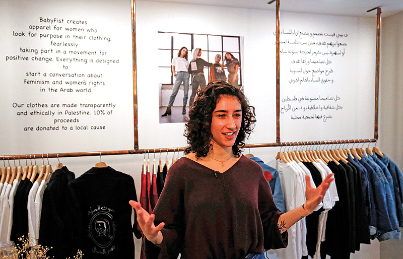 Palestinian fashion designer Yasmeen Mjalli speaks while standing in her clothing shop where her label collection “BabyFist” carrying anti-sexual harassment slogans is showcased. — AFP photos