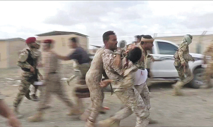 An image grab taken from a video obtained by AFPTV shows a wounded Yemeni soldier being carriednby comrades after a drone exploded above Yemen’s al-Anad airbase in the government-held southernnprovince of Lahj. — AFP