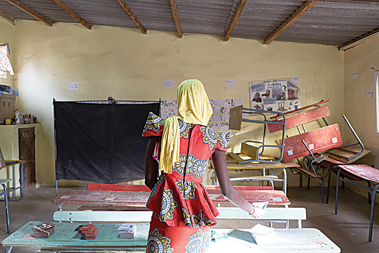 A woman gets ready to cast her ballot for Senegalís presidential elections at a polling station in Thies on February 24, 2019. - Senegal went to the polls in an election that incumbent President Macky Sall is tipped to win after his main challengers were banned from running. His two biggest rivals in the first-round vote in the West African nation -- popular former Dakar mayor Khalifa Sall and Karim Wade, the son of the previous president -- were disqualified after corruption convictions in trials questioned by rights groups. (Photo by MICHELE CATTANI / AFP)