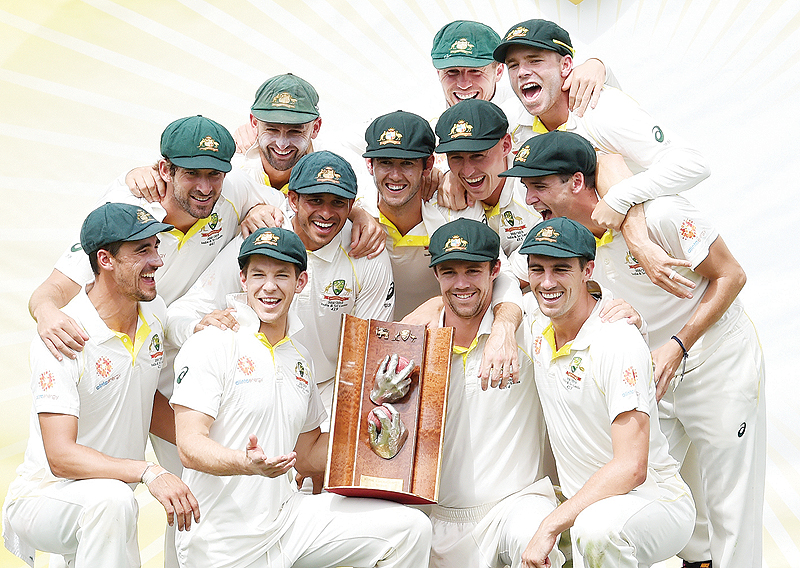 CANBERRA: Australian players pose with the winning trophy after defeating Sri Lanka’s in the second Test cricket match between Australia and Sri Lanka at the Manuka Oval Cricket Ground in Canberra yesterday. —AFP