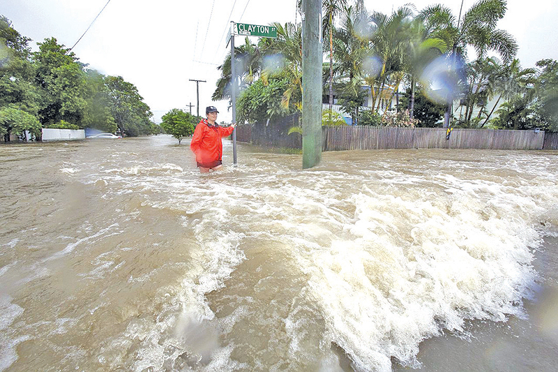 QUEENSLAND: Resident Amelia Rankin in flooded waters in Hermit Park, Townsville, Queensland. — AFP