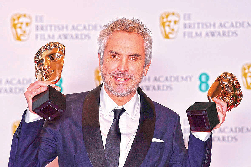 Mexican director Alfonso Cuaron poses with the awards for a Director and for Best Film for “Roma” at the BAFTA British Academy Film Awards at the Royal Albert Hall in London