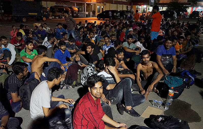 Bangladeshi nationals are seen gathered outside a police station following a raid on a shop house in Medan on February 6, 2019 AFP