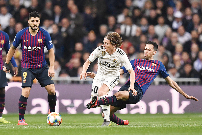 MADRID: Barcelona's Spanish midfielder Sergio Busquets (R) vies with Real Madrid's Croatian midfielder Luka Modric during the Spanish Copa del Rey (King's Cup) semi-final second leg football match between Real Madrid and Barcelona at the Santiago Bernabeu stadium in Madrid on Wednesday. – AFP 