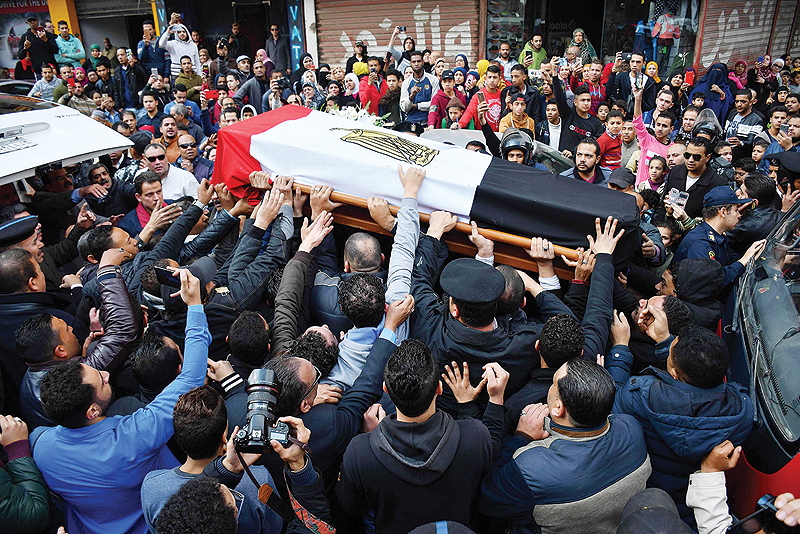 CAIRO: Mourners carry the coffin of Egyptian policeman Mahmud Abu El-Yzied during his funeral in the Embaba district of the capital yesterday. — AFP